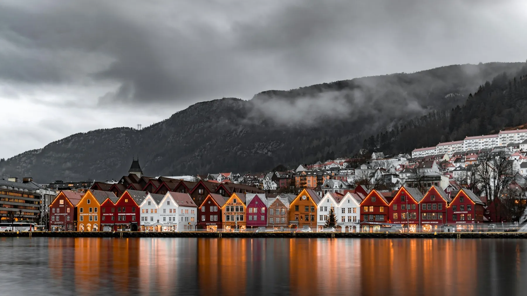 Fargerike trehus på Bryggen i Bergen under skyer